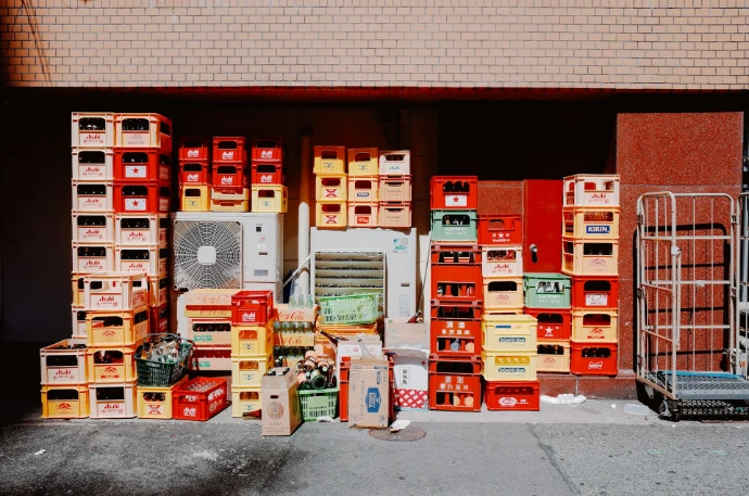 Stacks of colorful beverage crates outside a building